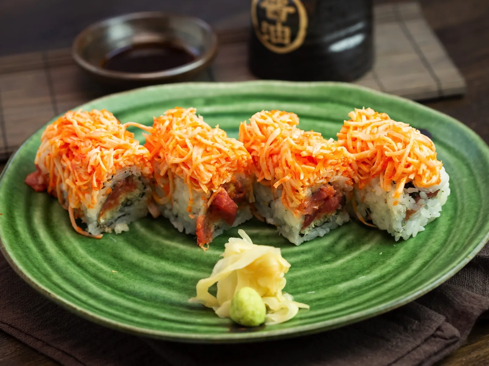 Crunch-topped rolls on a green plate at Kikoo Sushi
